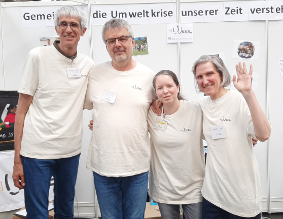 Die The Week Botschafter*innen Matthias Leube, Jürgen Harder, Jenny Scholl und Barbara Leube stehen an einem Infostand zu The Week beim Evangelischen Kirchentag 2025 in Hannover.