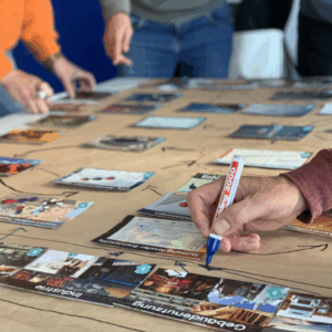 Nahaufnahme der Karten eines Climate Fresk-Workshops auf einem Tisch.